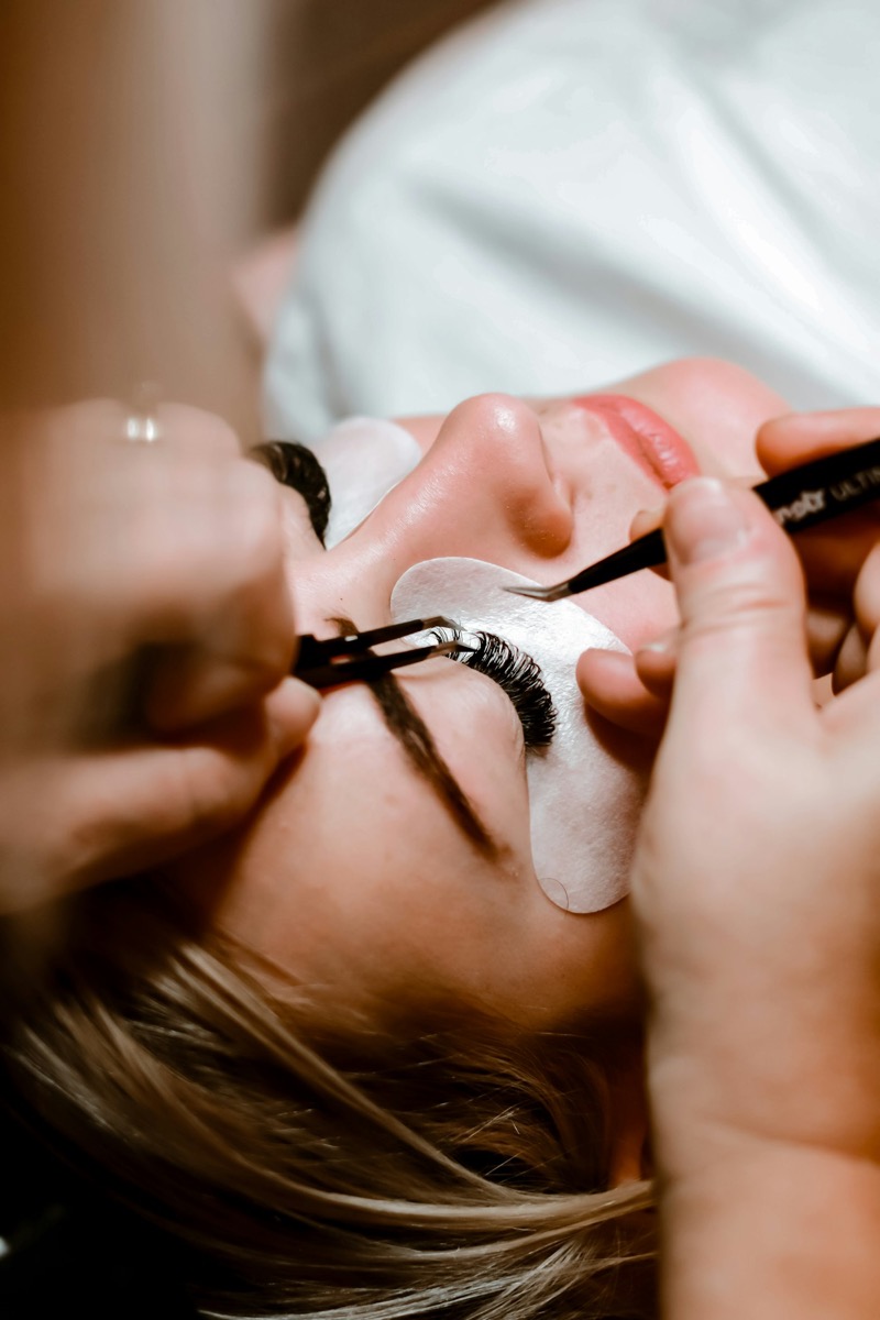 Lash extensions being applied with fine tweezers